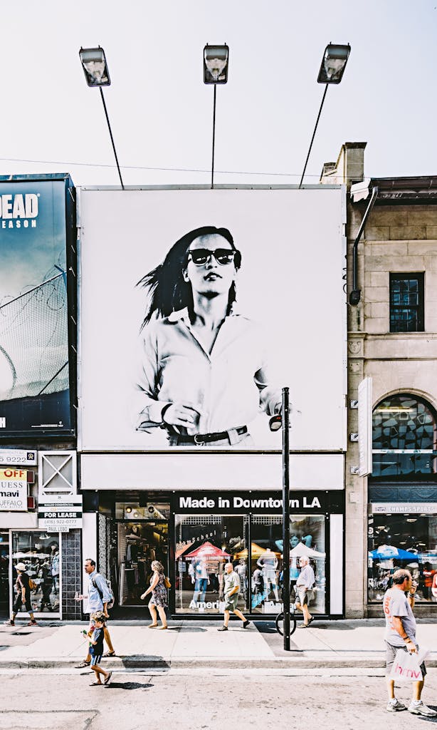 Busy Toronto street with shops, people, and large advertisement in urban setting.